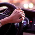 Woman driving a modern car at night in a city